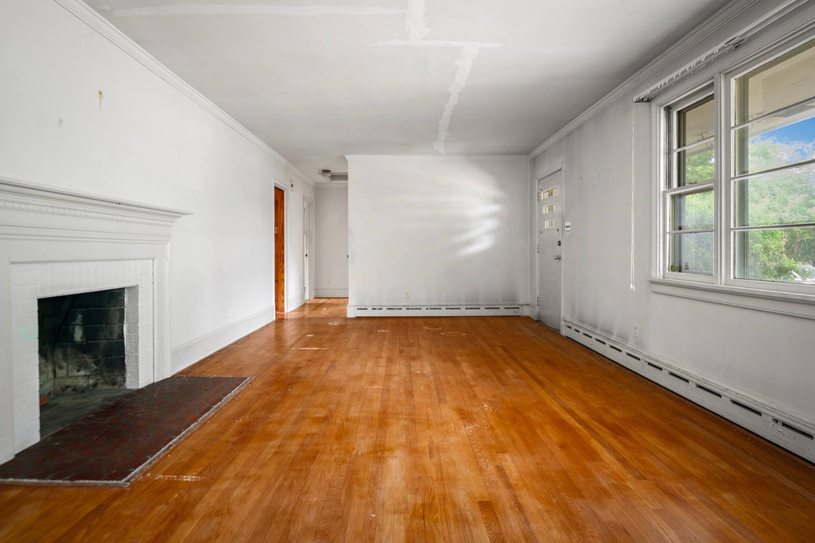 The living room at 1407 Wentbridge Road, with original oak hardwood floors and a brick fireplace
