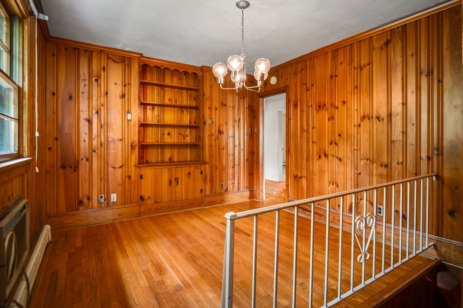 The dining area in knotty pine, with built-in shelving and a corner cupboard