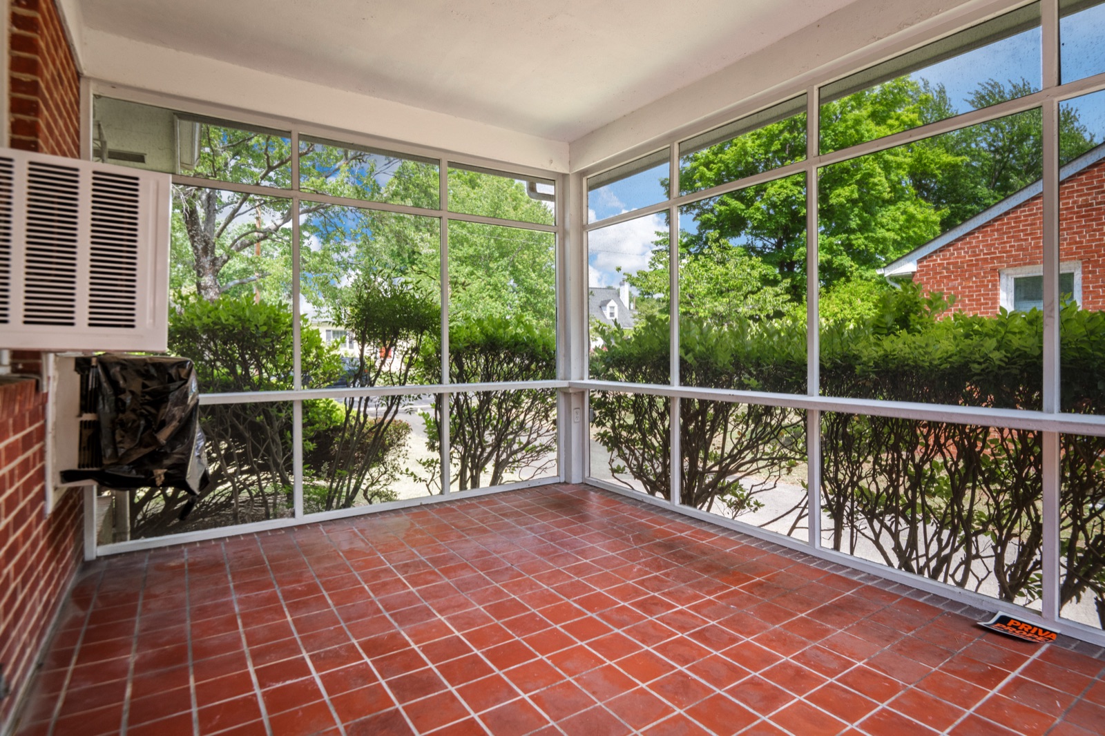 The screened side porch at 1407 Wentbridge Road, with its original red quarry tile floor