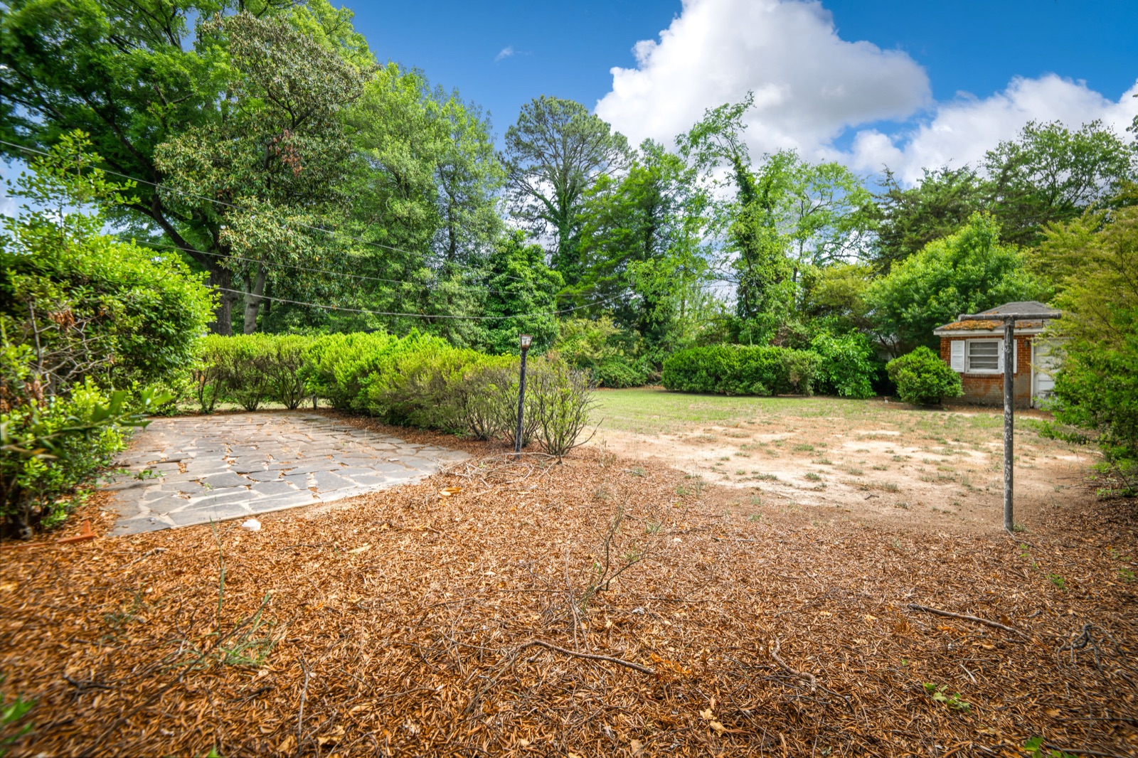 The backyard at 1407 Wentbridge Road — a deep Northside lot with a brick outbuilding